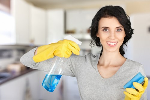 Cleaner using commercial carpet cleaning equipment in a workspace